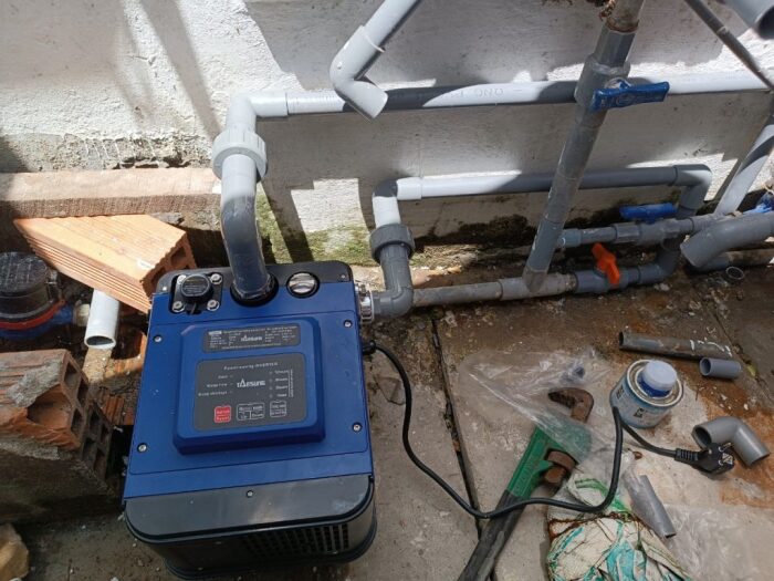 Thợ lắp đặt máy bơm trợ lực cho nguồn nước sạch bị yếu